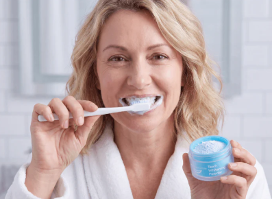 Woman brushing teeth with MySweetSmile whitening powder and toothpaste